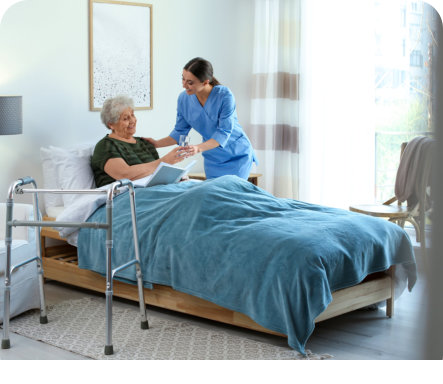 a female caregiver assisting an elderly woman on a bed
