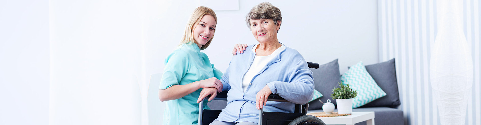 a female caregiver with an elderly woman smiling